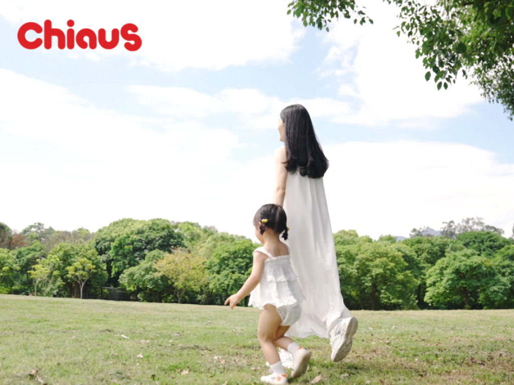 a baby girl wear chiaus training pants running on park with mom