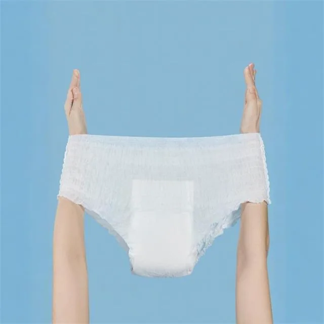Hands holding an adult pull-up diaper against a blue background